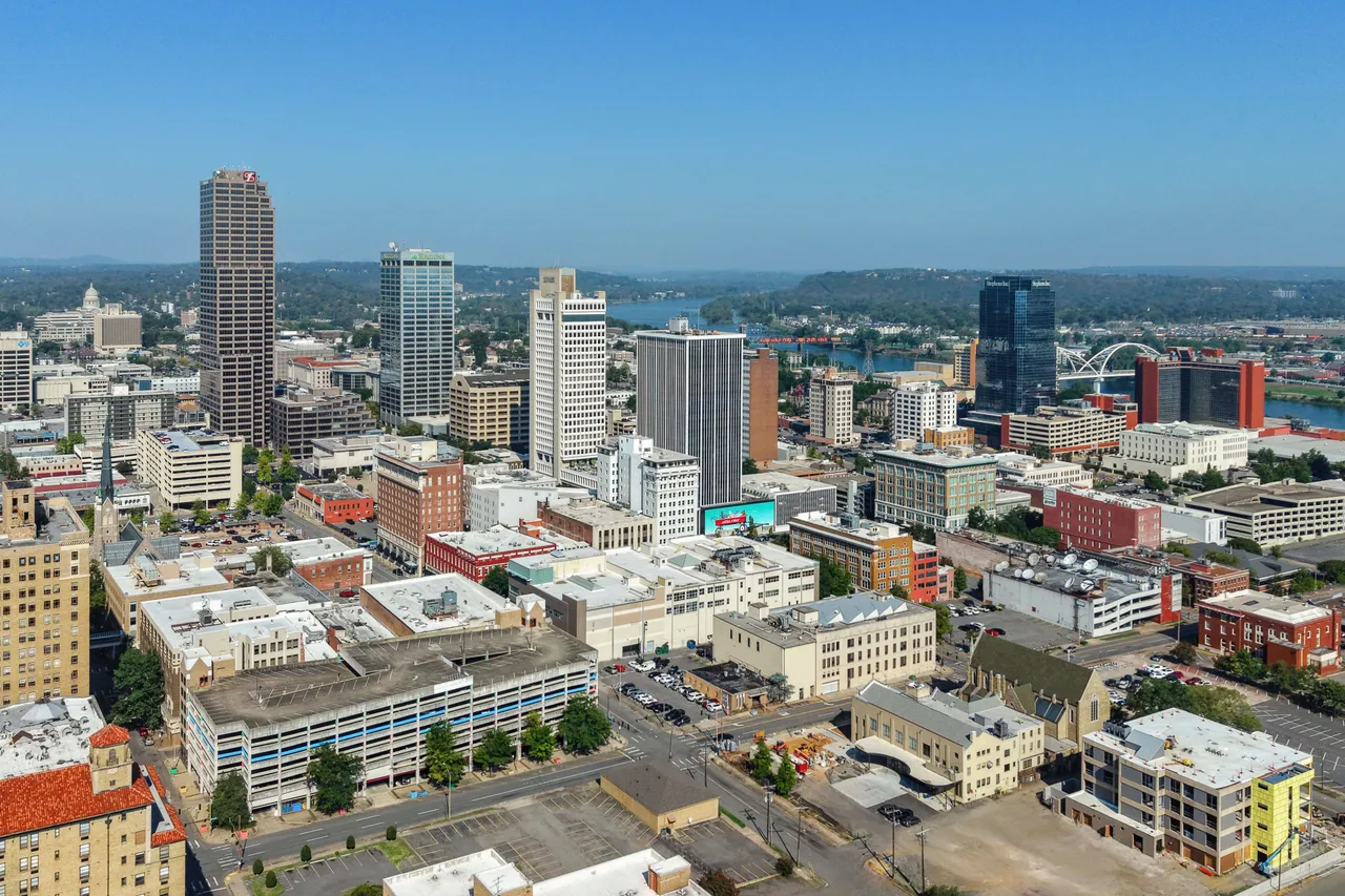 Real aerial photograph of downtown Little Rock, with the Arkansas River and bridges beyond the skyline